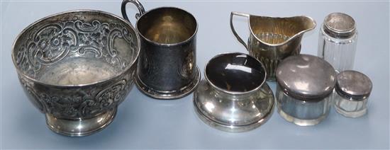 An Edwardian silver christening mug, a repousse silver bowl, a silver cream jug, mounted inkwell and three mounted jars.